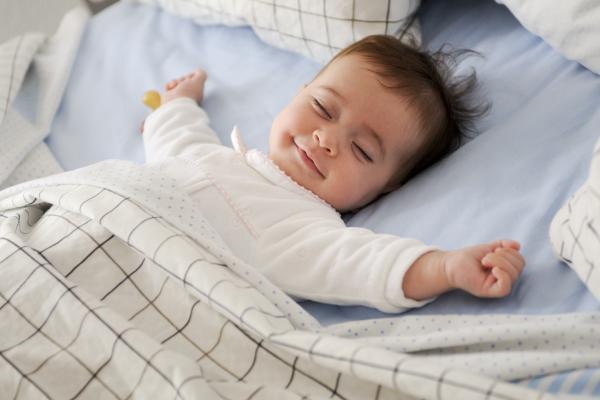 bébé qui dort en souriant